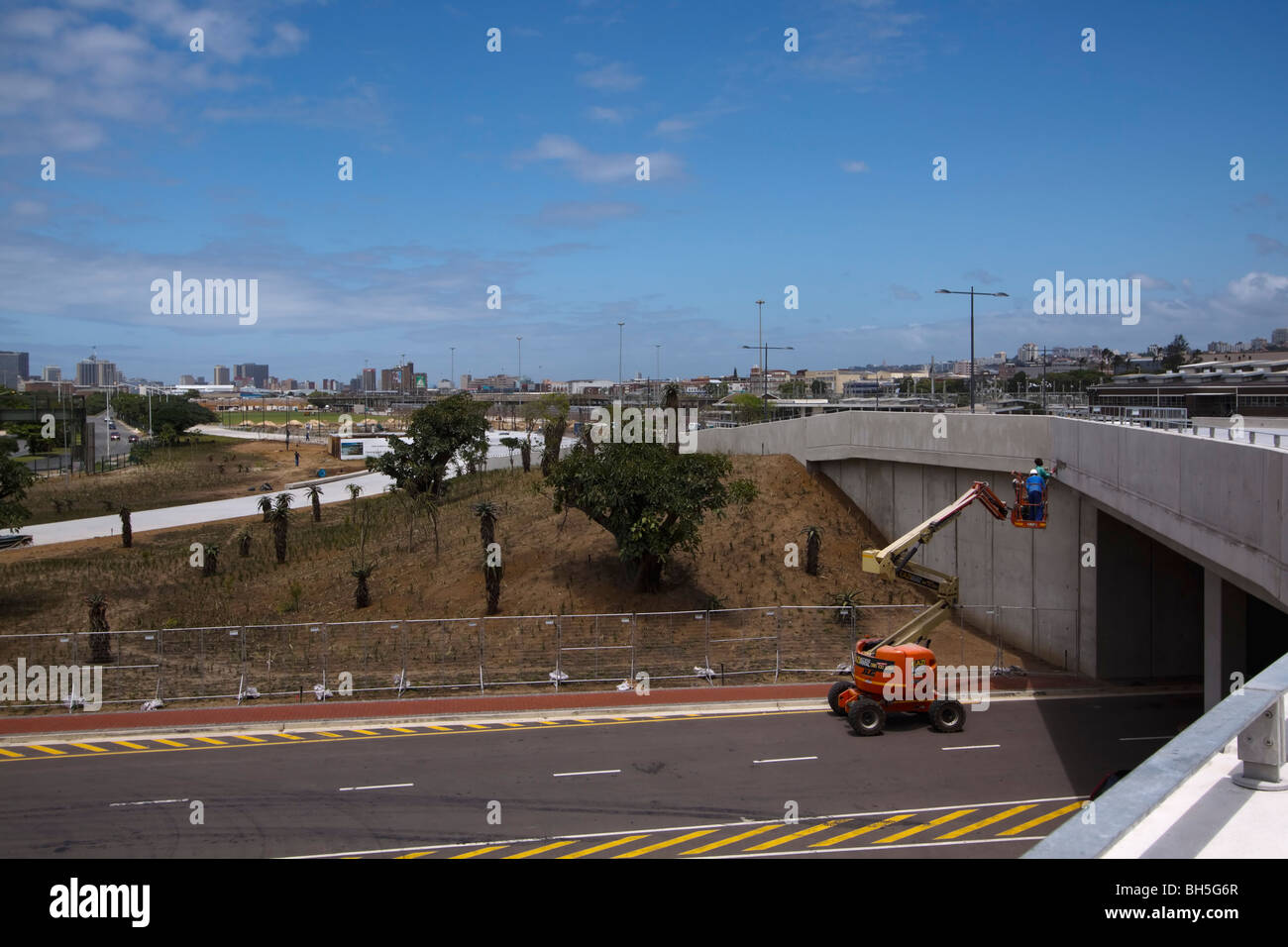 I lavoratori su una piattaforma di sollevamento mettere tocchi di rifinitura per nuovi lavori stradali. Durban, Kwazulu Natal, Sud Africa. Foto Stock