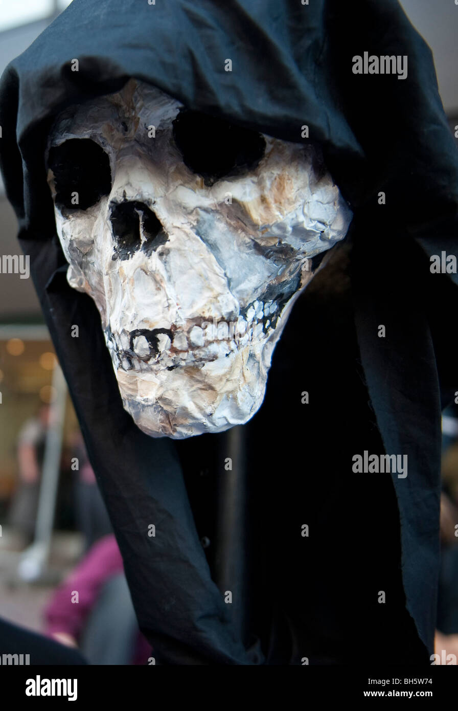 Una maschera di morte a bracci anti-commercio protesta nella città di Londra Foto Stock