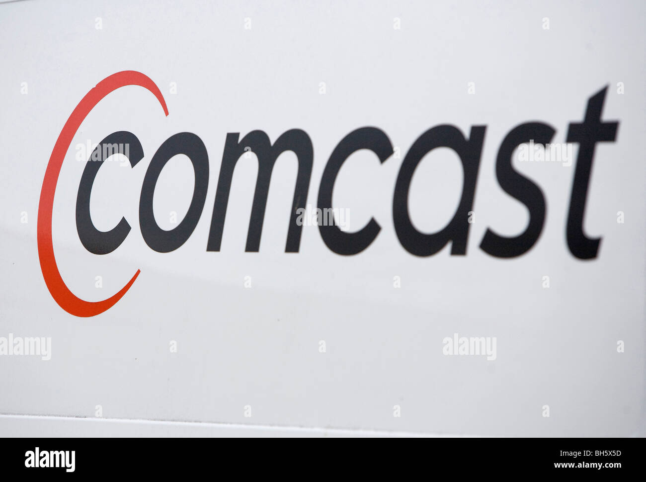 Un Comcast Corporation logo su un veicolo nella parte anteriore di una parabola satellitare. Foto Stock