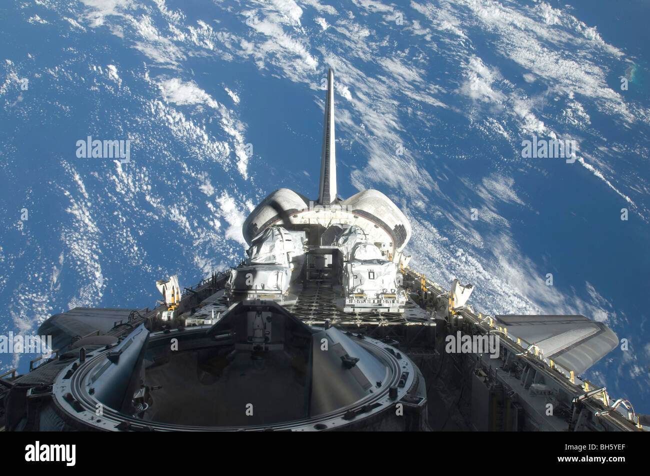 Una vista parziale della navetta spaziale Atlantis backdropped da un blu e bianco messa a terra. Foto Stock