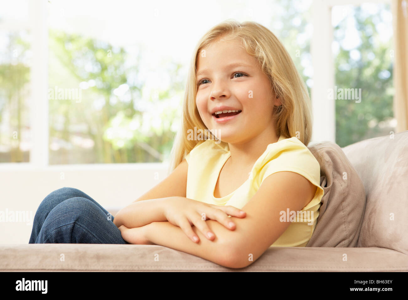 Giovane ragazza rilassante sul divano di casa Foto Stock