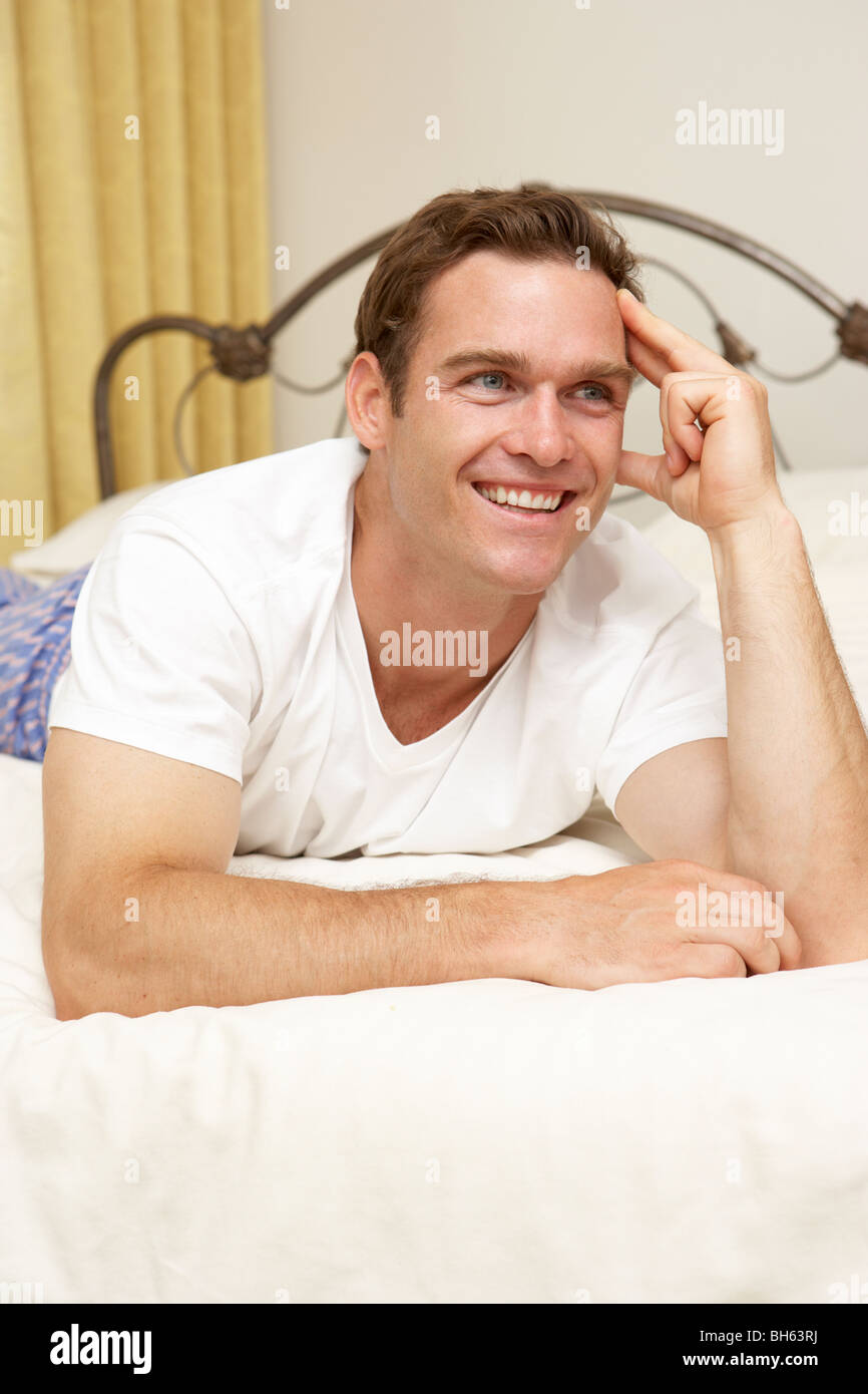 Uomo relax su letto di casa Foto Stock