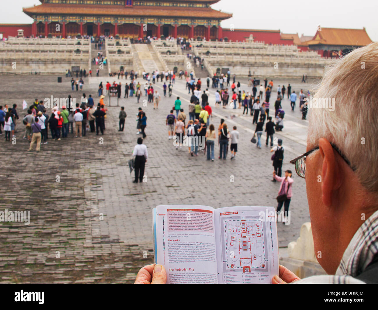 Western studi turistici libro guida, mentre in piedi nella motivazione della Città Proibita di Pechino Foto Stock