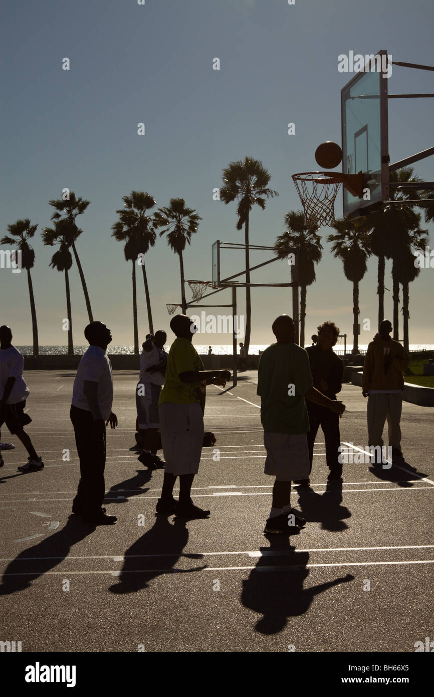 Gli uomini giocare a basket in una giornata di sole in spiaggia venezia, Los Angeles, California, US Foto Stock