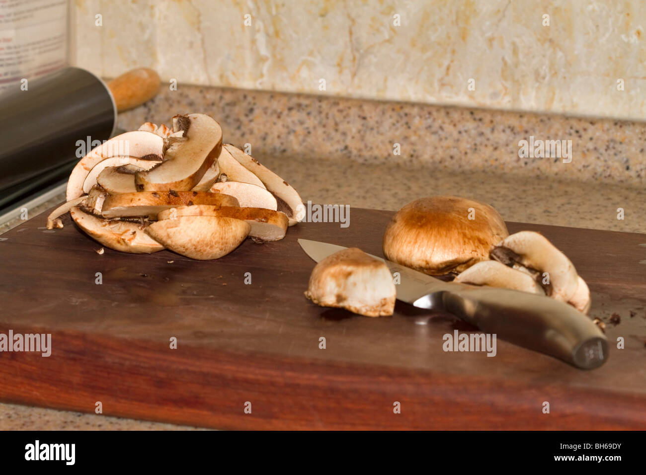 Trinciatura di piccoli funghi champignon Foto Stock