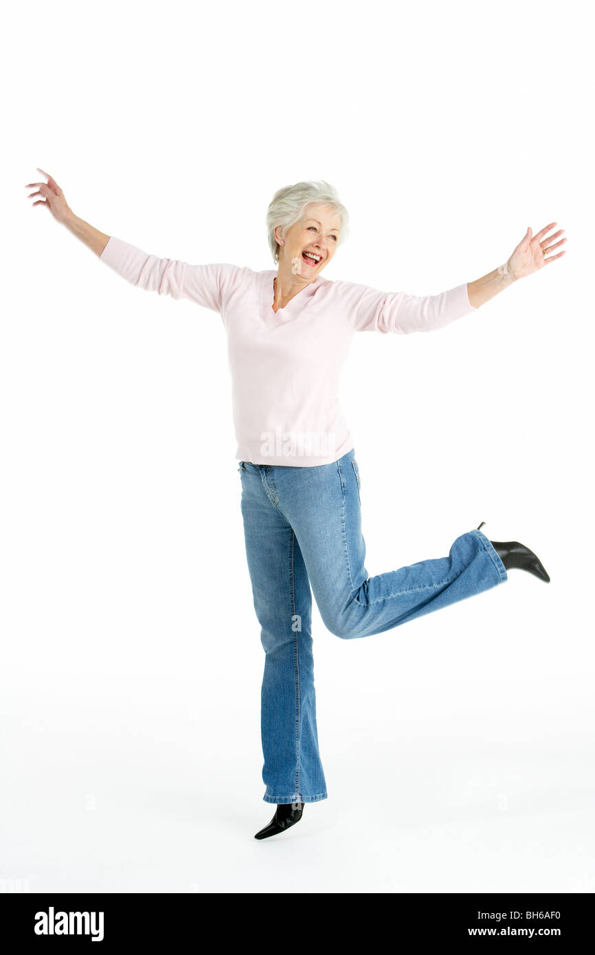 A piena lunghezza ritratto in studio di sorridere Senior Donna Foto Stock