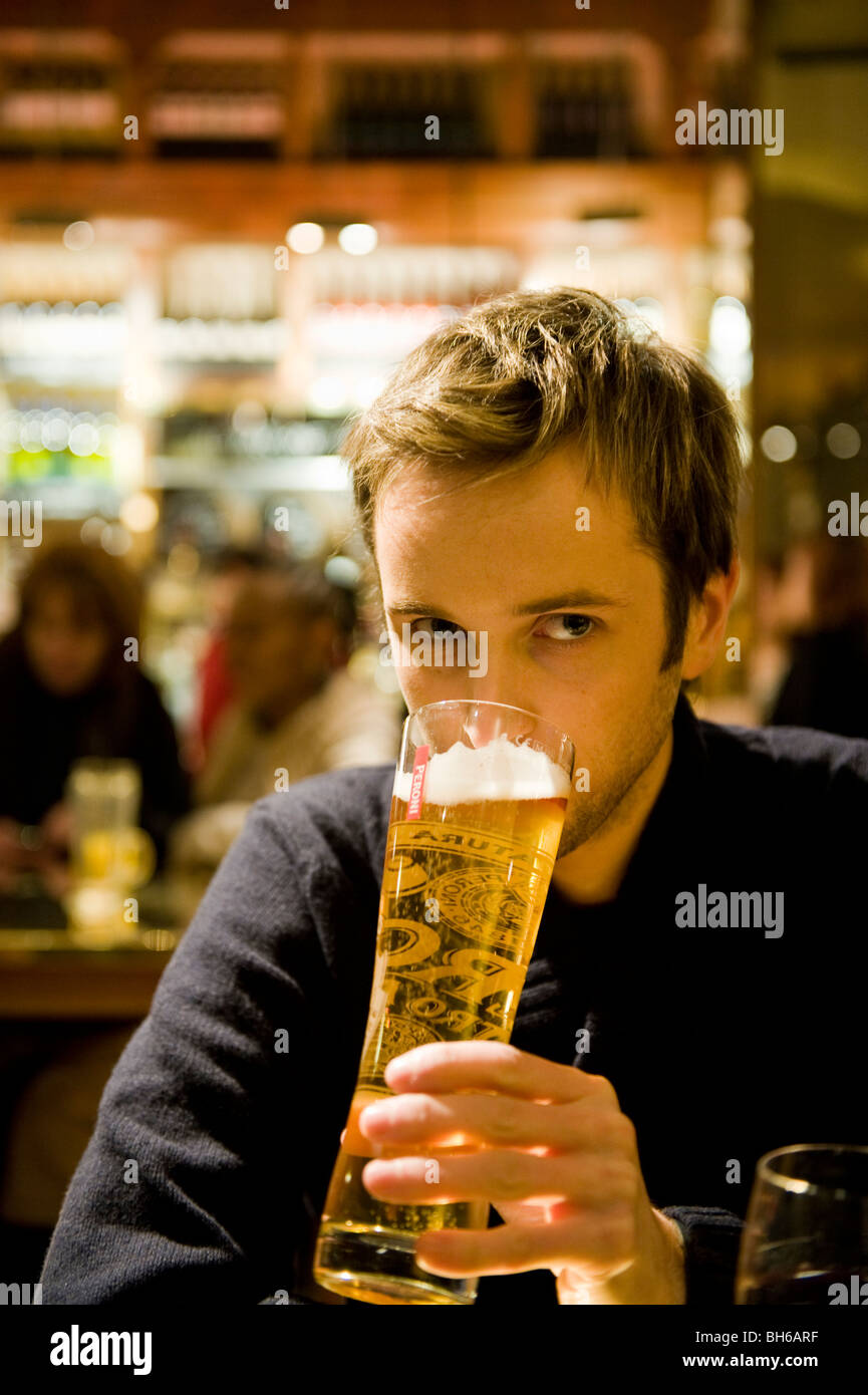 Un giovane uomo di bere in un bar Foto Stock