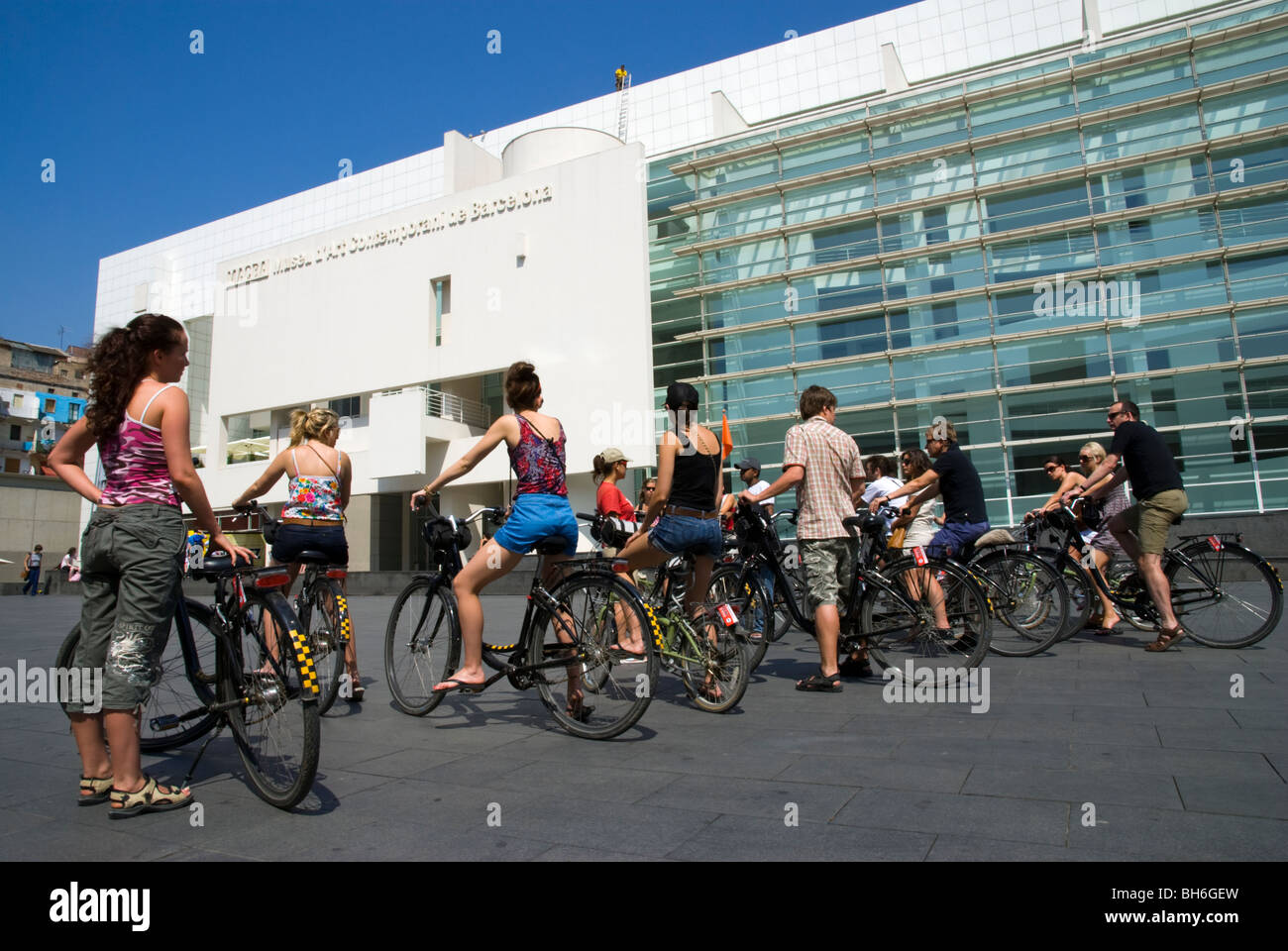 Giovani turisti in un tour in bicicletta di fronte al MACBA (Museu d'Art Contemporani de Barcelona).Barcellona Cataluña. Spagna. Foto Stock