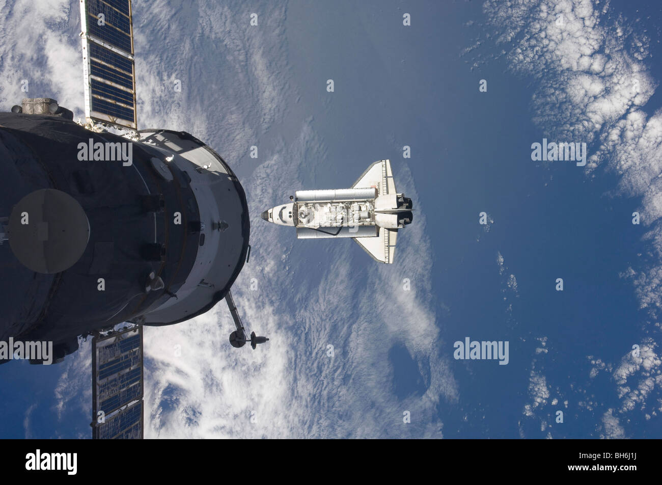 Lo Space Shuttle Atlantis e un veicolo spaziale russo backdropped da un blu e bianco messa a terra. Foto Stock