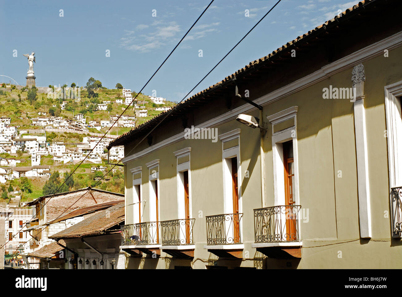 Equador, Quito Quito la Madonna a basso angolo di visione di un bianco coloniale casa residenziale, con case in background sulla montagna Foto Stock