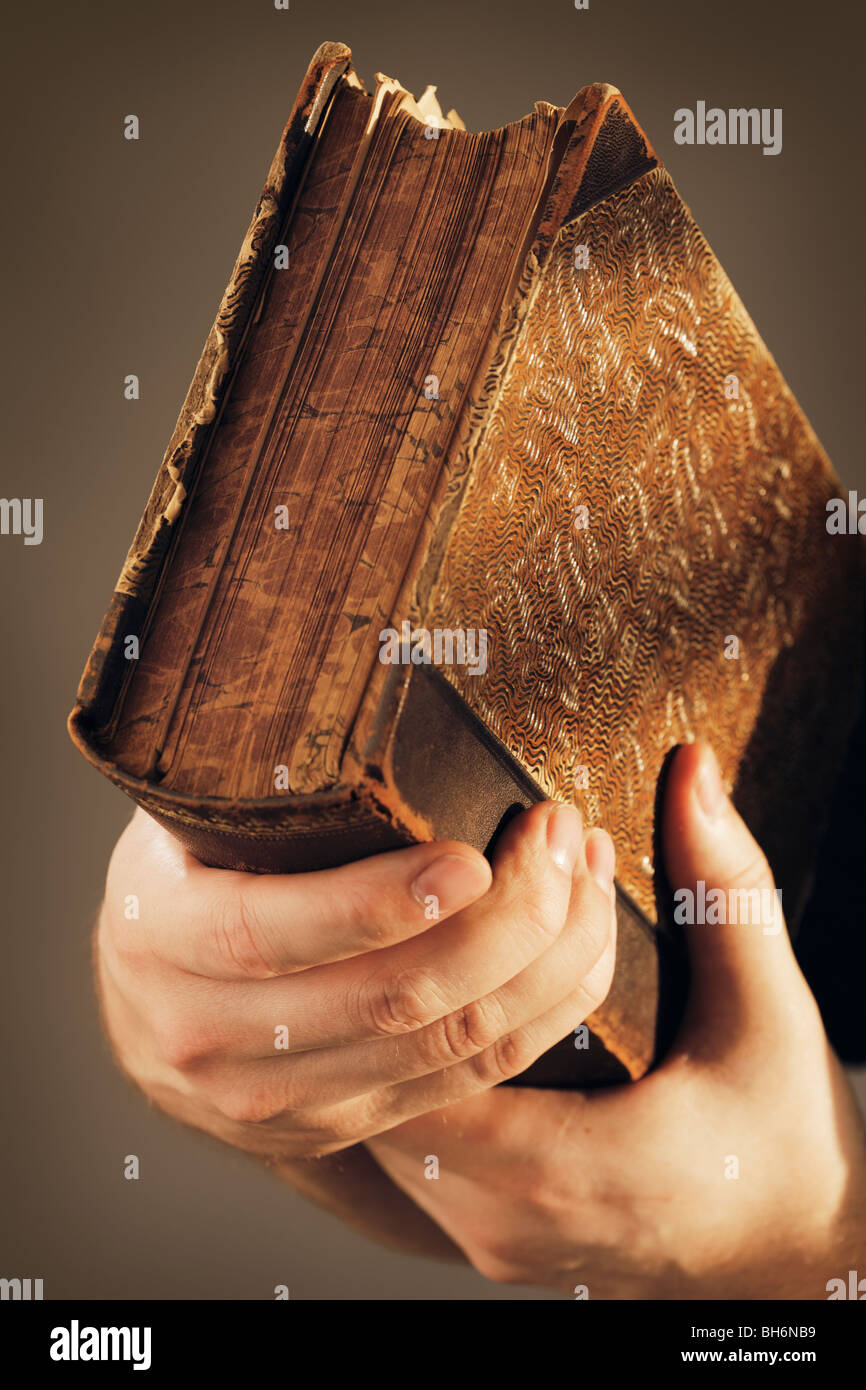 Mani tenendo un importante libro antico Foto Stock