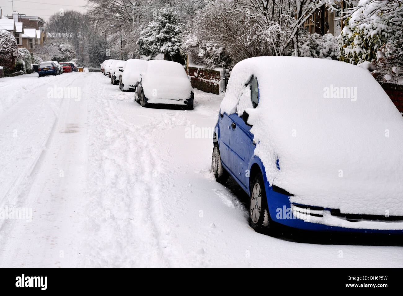 Coperta di neve macchine parcheggiate su strada residenziale, Bristol, Regno Unito Foto Stock