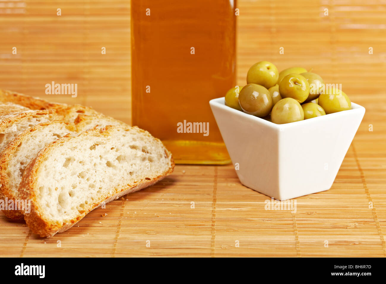 Pane e olio di oliva Bottiglia e alcune olive su sfondo di legno. Profondità di campo Foto Stock