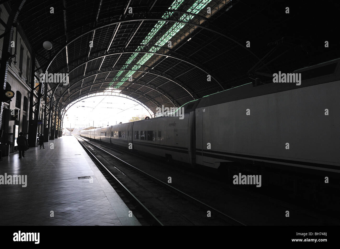 Interno della stazione ferroviaria di cross-luce con fermato il treno e la piattaforma vuota Foto Stock