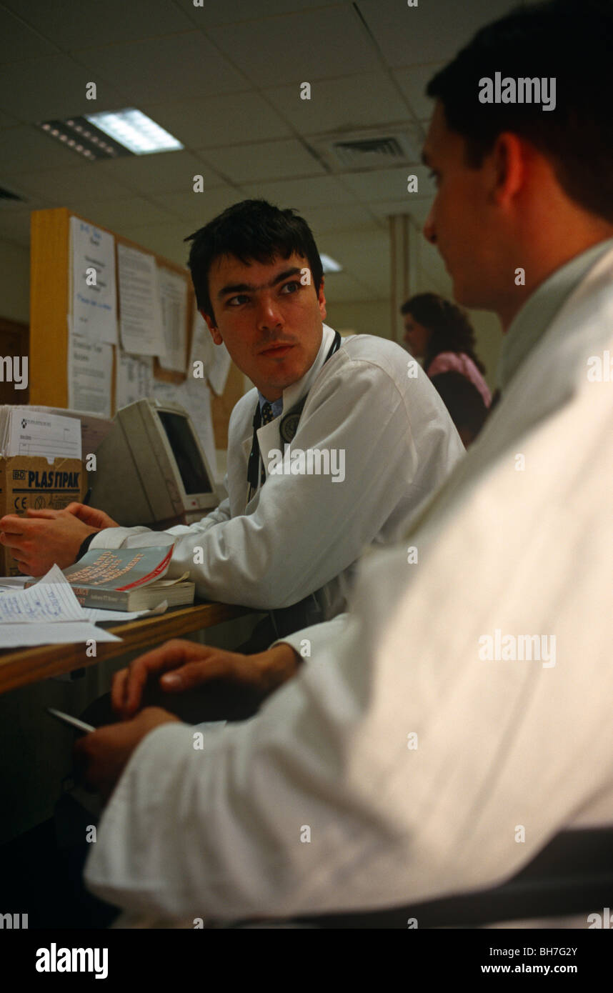 I giovani medici discutono il trattamento di un paziente su un occupato sabato notte in un&E del Royal London Hospital Whitechapel Foto Stock