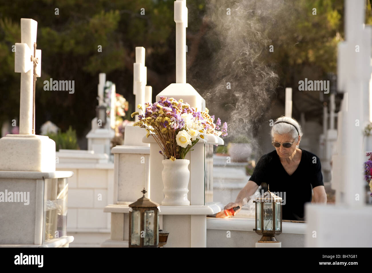 Pulizia vedova tomba nel cimitero, Naxos, Grecia. Foto Stock