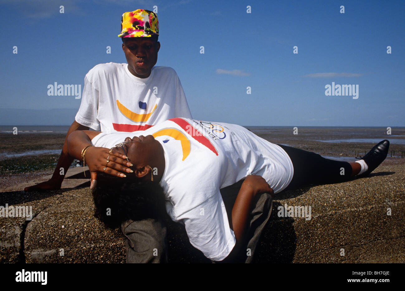 Un giovane nero giovane godere della reciproca compagnia sul mare muro di difesa mentre è in vacanza a Minehead, Somerset. Foto Stock