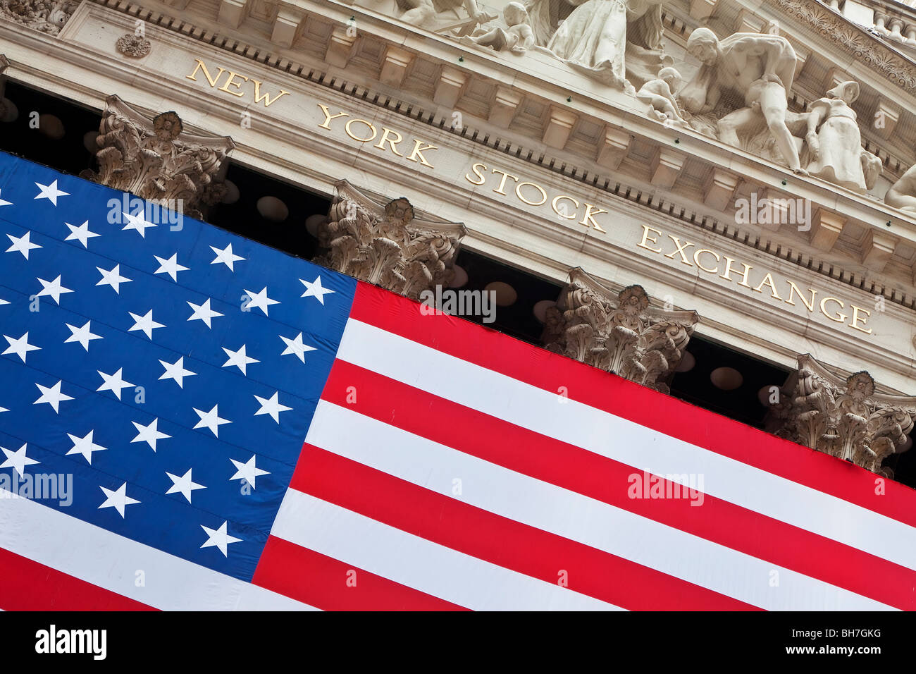 Stati Uniti d'America, New York City, Manhattan, quartiere finanziario del centro cittadino - Wall Street e noi bandiera appesa al di fuori del New York Stock Exchange Foto Stock