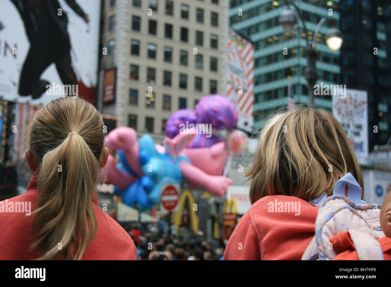 Due ragazze a guardare il Macy's Thanksgiving Day Parade passano attraverso Times Square. Foto Stock