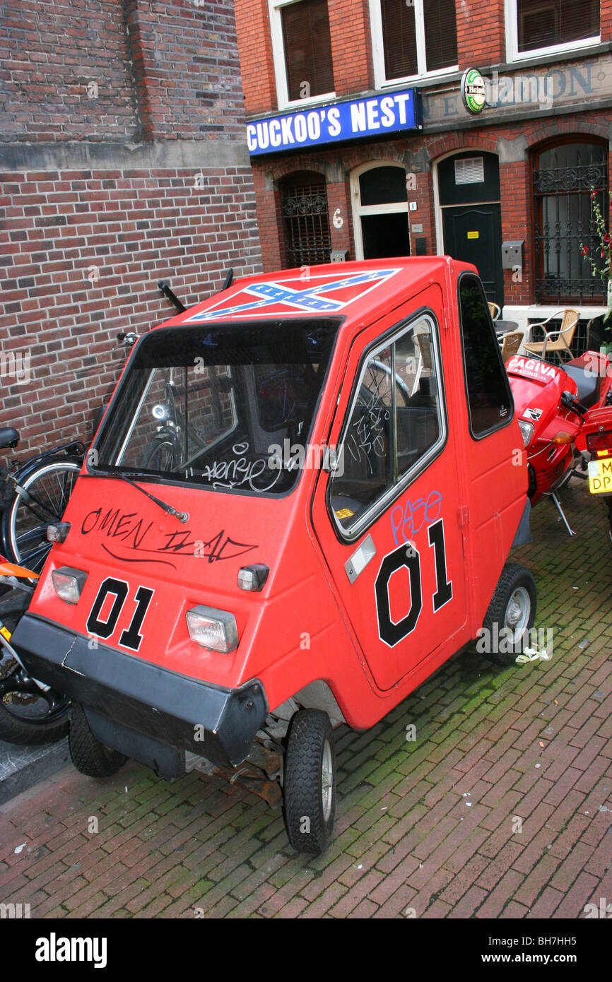 Funny microcar nel vicolo di Amsterdam, Paesi Bassi, dipinta come il Generale Lee da "duchi di Hazzard" Foto Stock
