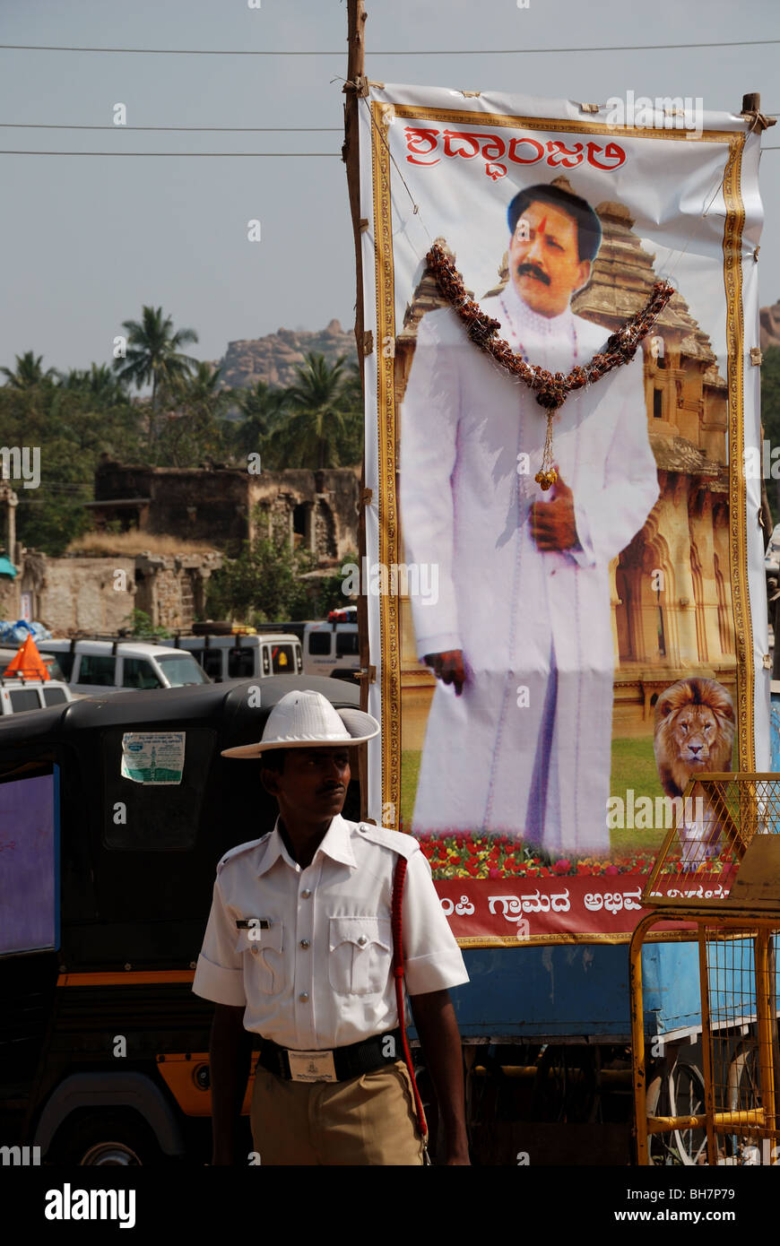 Poliziotto indiano di fronte politico poster della campagna, Hampi, India. Foto Stock