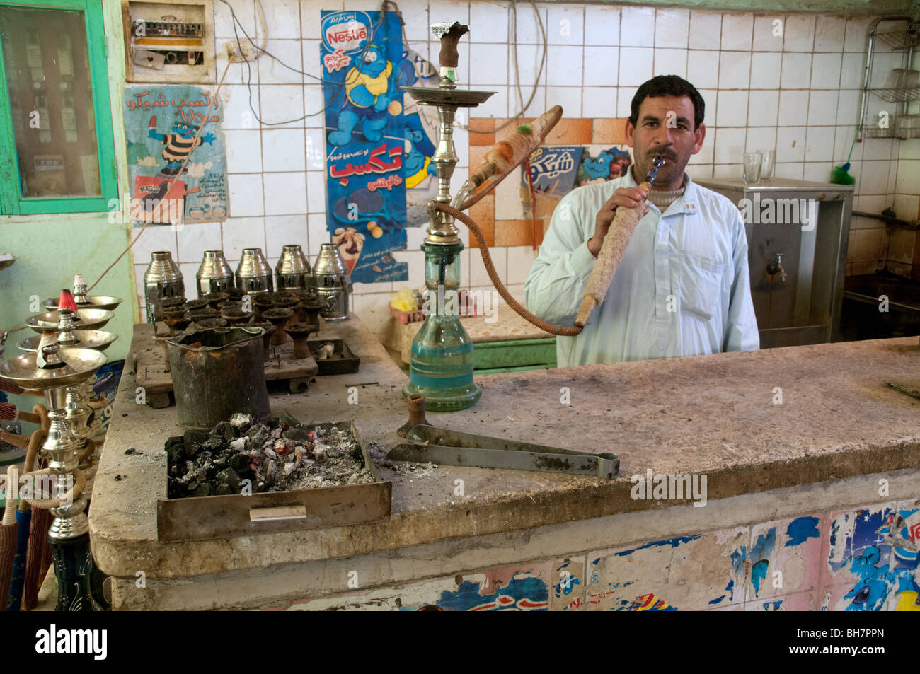Un coffee shop illuminazione dipendente fino a hookah tubo nel villaggio di al-qasr, Dakhla Oasis, nel Deserto Occidentale Regione del Sahara, Egitto.. Foto Stock