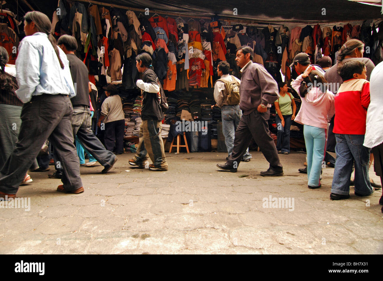 Ecuador, Otavalo, vista del mercato vestiti con gente che cammina sulla strada in primo piano, shopping Foto Stock