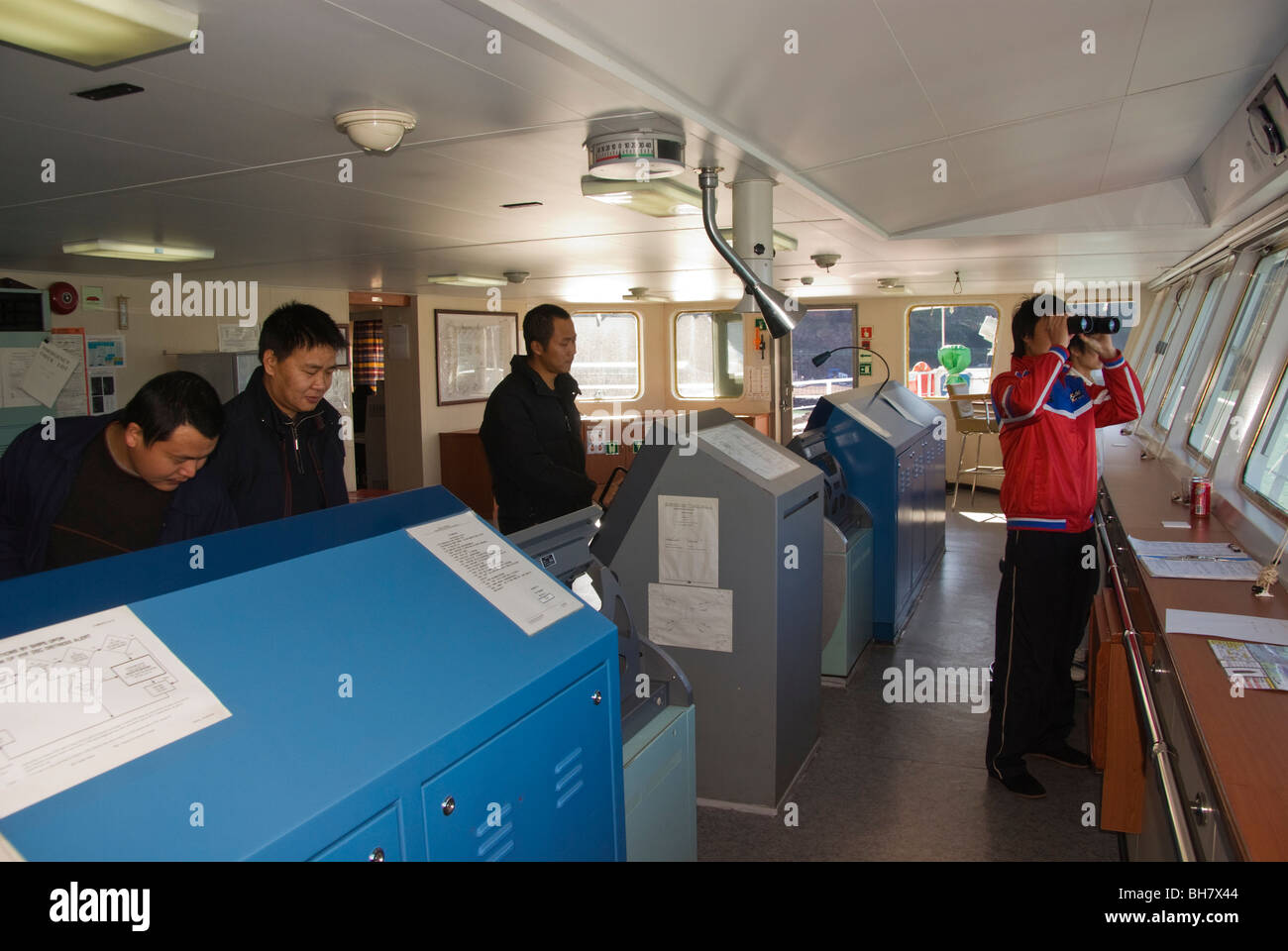 Capitano ed equipaggio sul ponte di una nave che entra in porto. Foto Stock