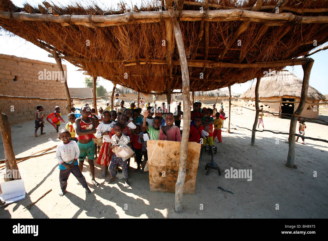 I bambini a scuola in Colui, Angola meridionale. La classe camera è all'aperto sotto un make-shift tetto di paglia. Foto Stock