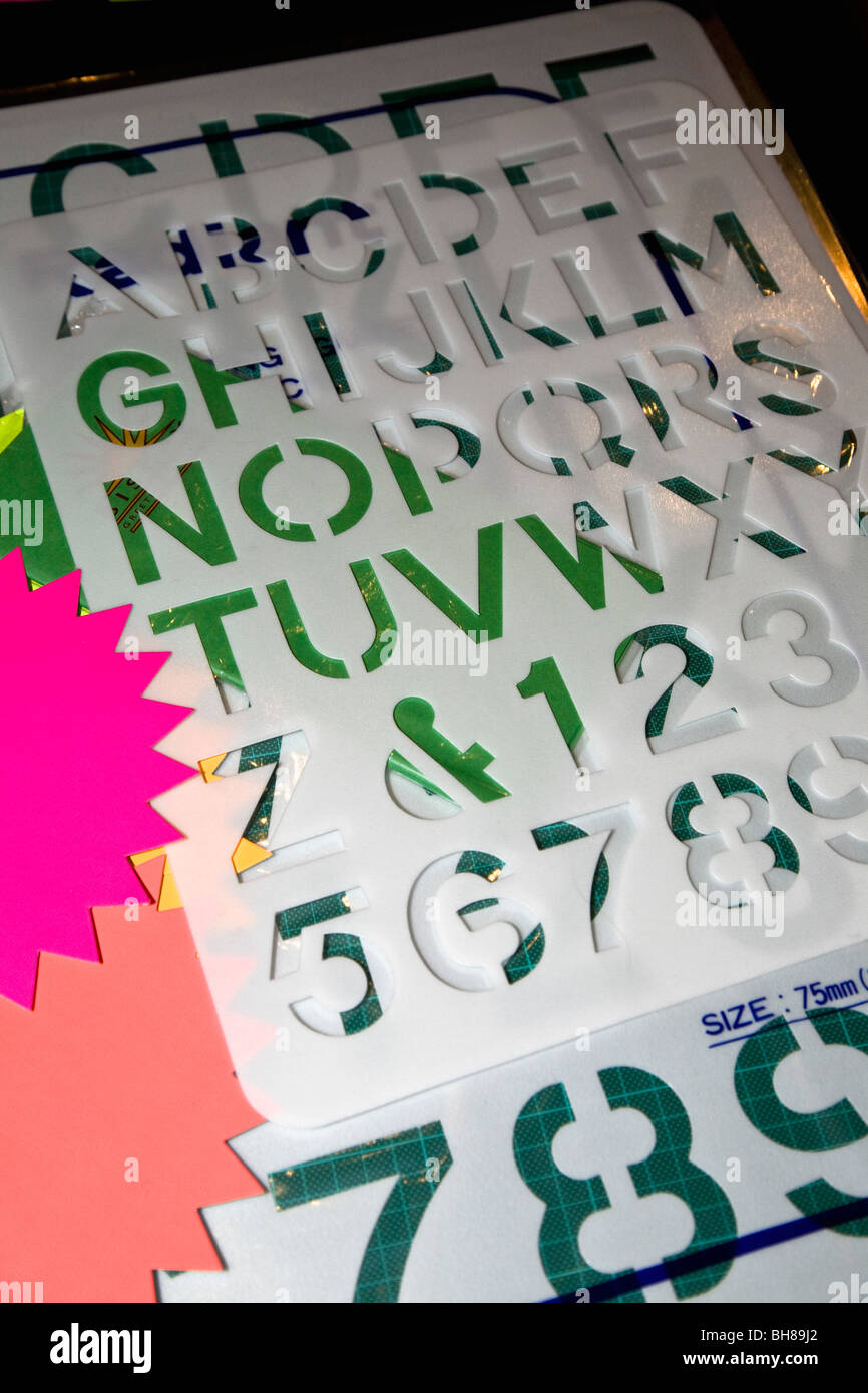 Lettera e numero stencil, carta colorata e un tappeto di taglio Foto Stock