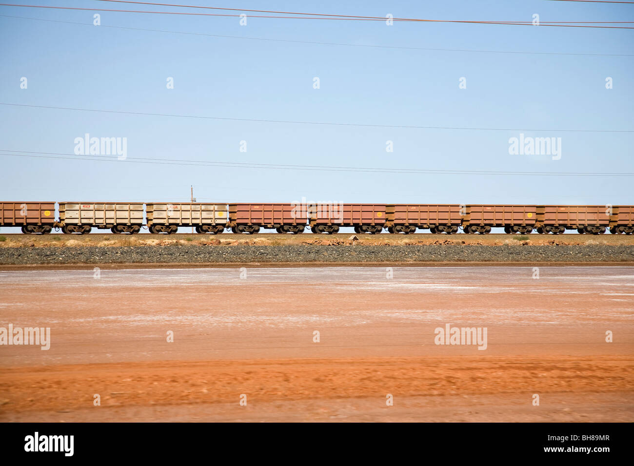 Treno merci che si muove attraverso un paesaggio deserto Foto Stock