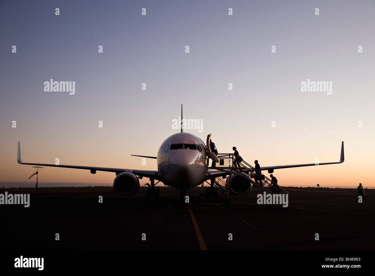 Le persone a bordo di un aereo al tramonto Foto Stock