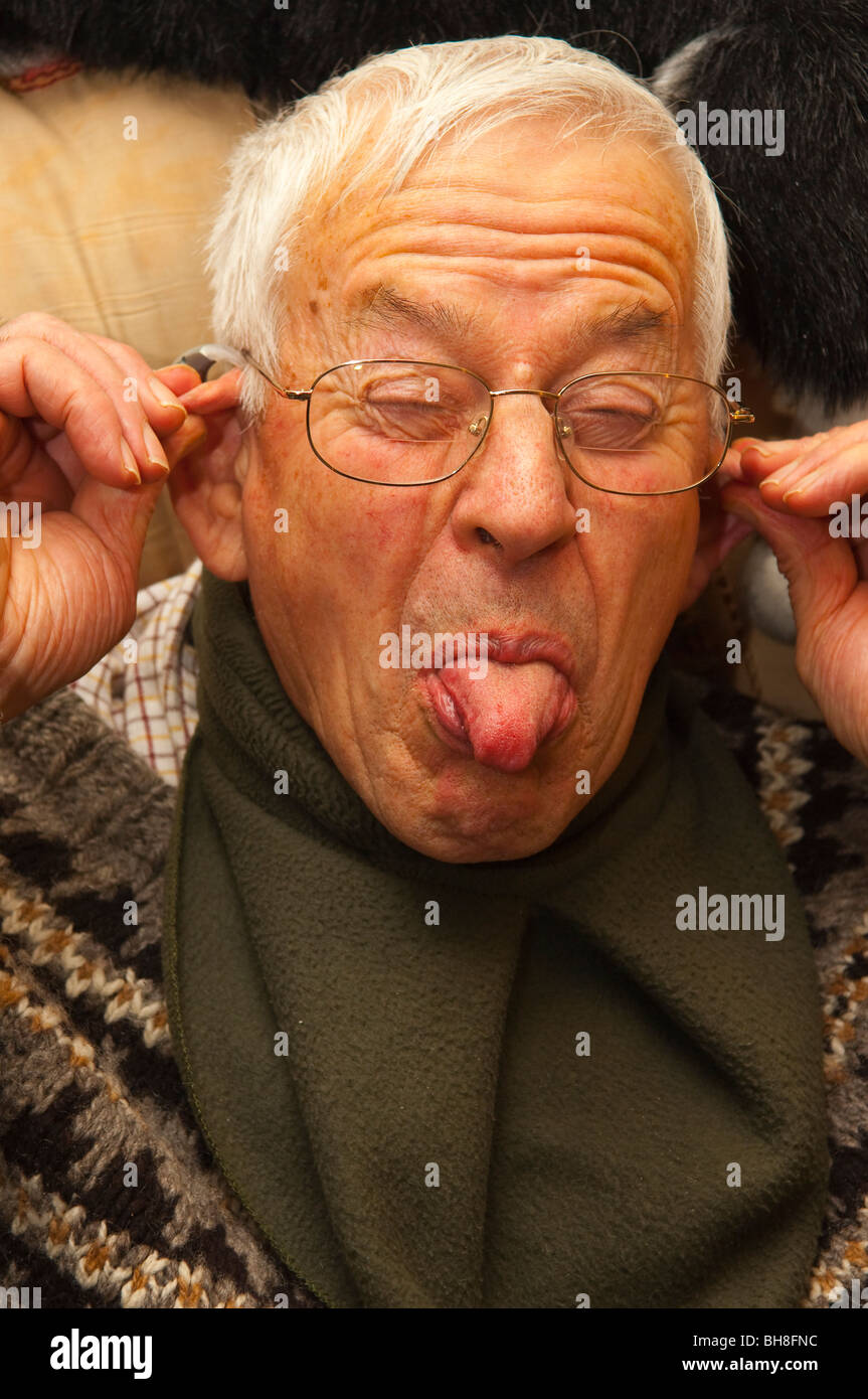 Un Modello rilasciato fino in prossimità di un uomo anziano nei suoi primi anni ottanta tirando una buffa faccia NEL REGNO UNITO Foto Stock