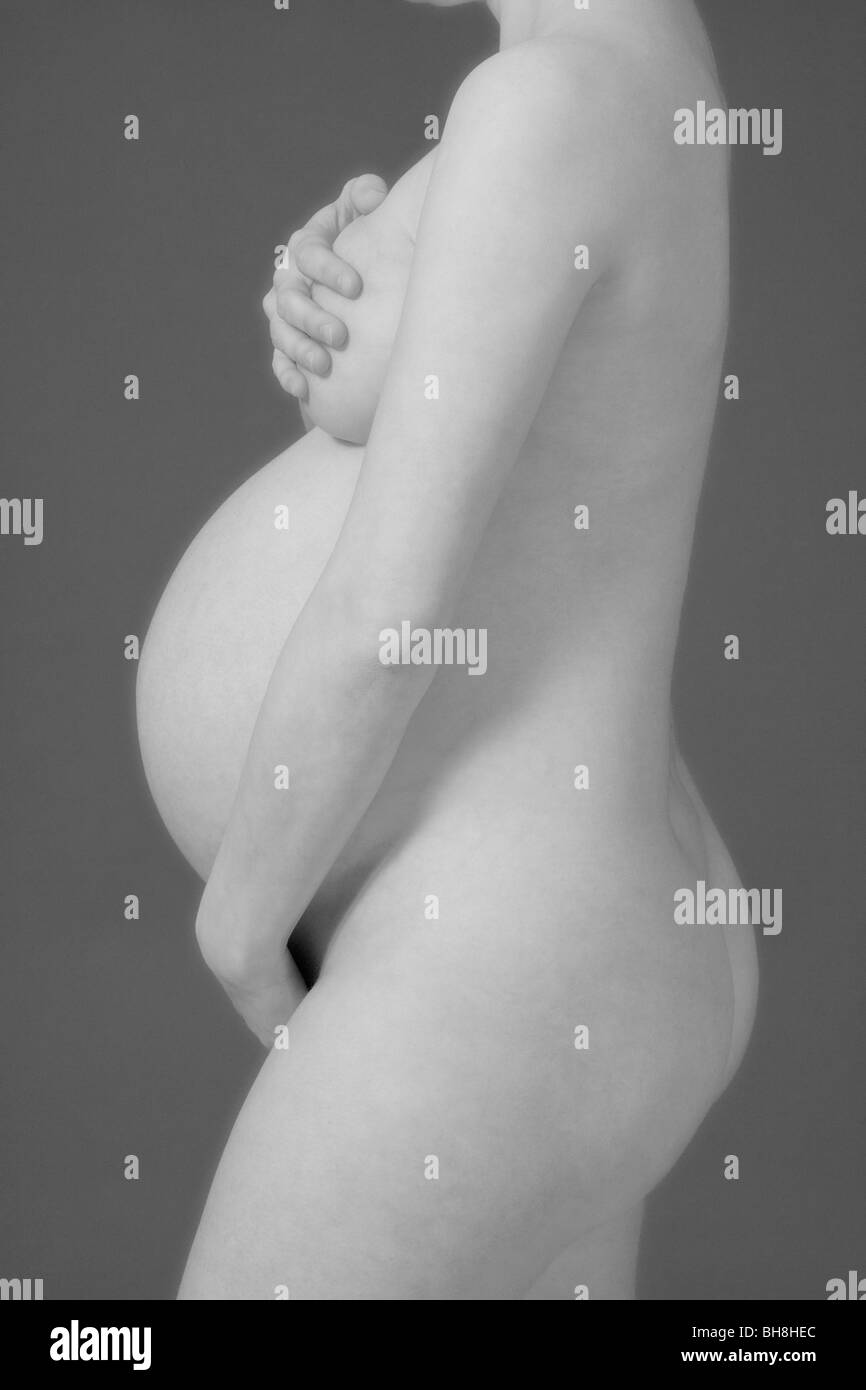 Aspetta la donna - studio shot di una donna in stato di gravidanza Foto Stock