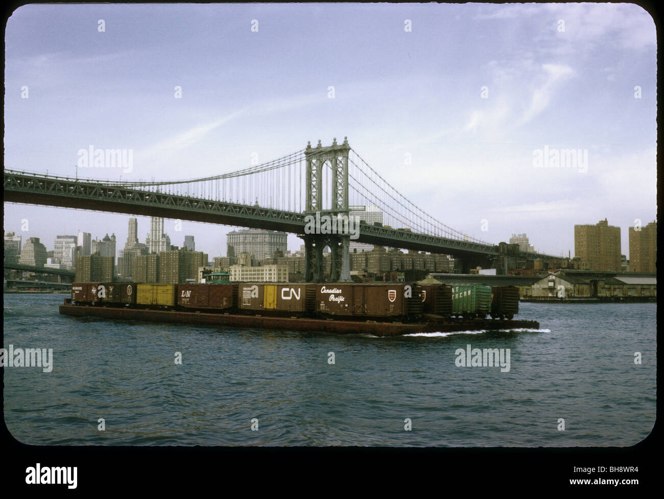 Una chiatta prende boxcars. 1968. Manhattan Bridge attraversa la East River tra Canal Street, Manhattan Flatbush Avenue,Brooklyn Foto Stock