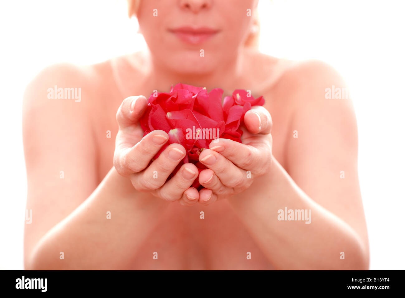 Donna e petali di rosa nel suo canto isolato su sfondo bianco Foto Stock
