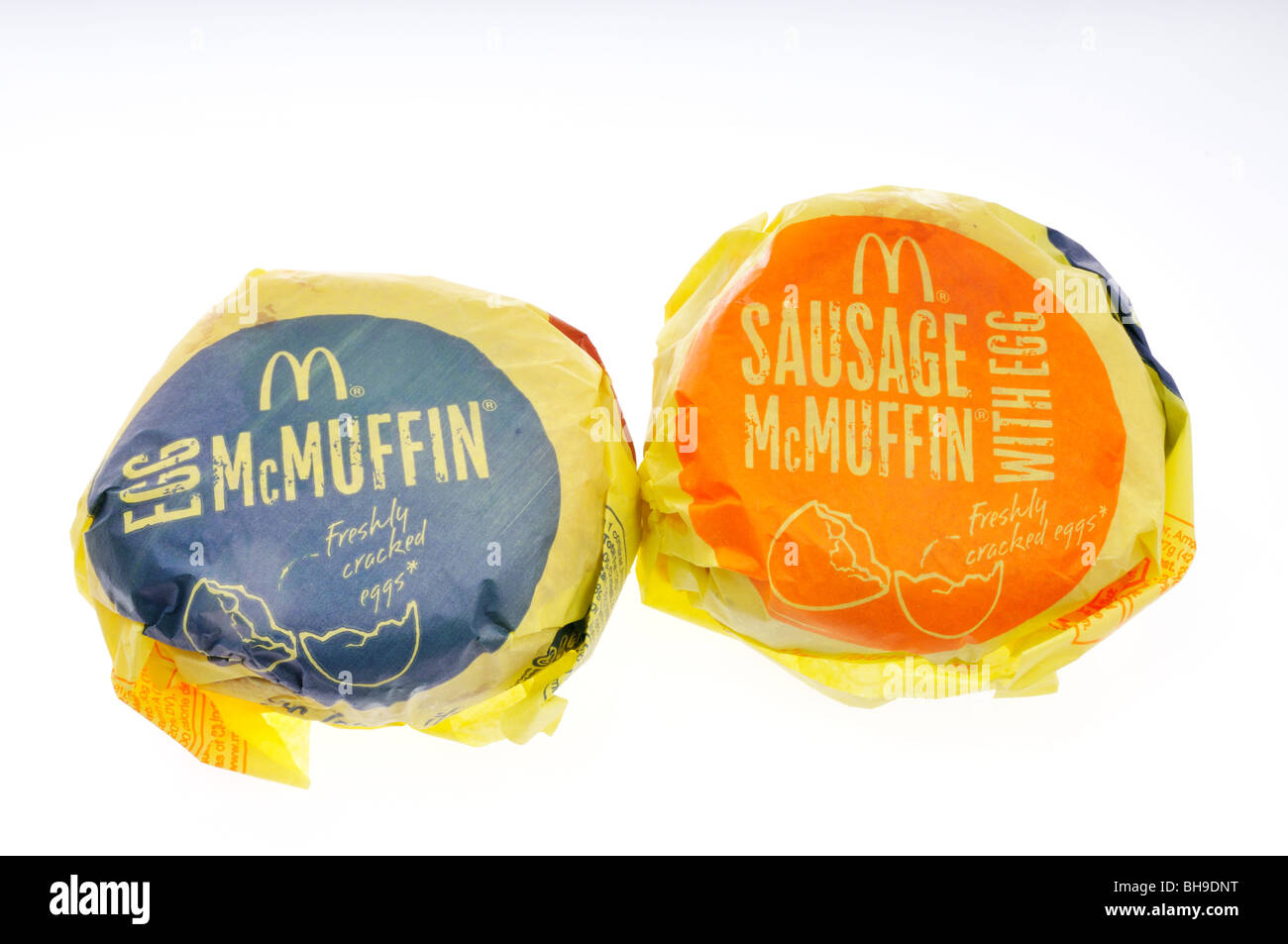 McDonald's McMuffin uova e salsiccia McMuffin panini colazione in involucri su sfondo bianco. Tagliare Foto Stock