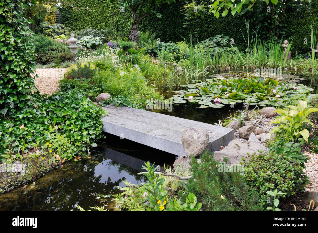 Laghetto in giardino con il ponte di pietra. design: marianne e detlef lüdke Foto Stock