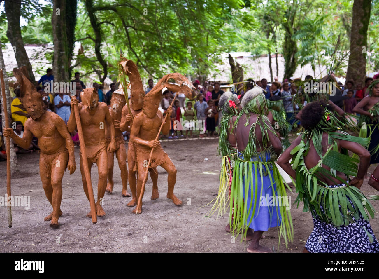 Il Melanesian uomini coperto di fango danza in un villaggio tradizionale danza con altri ballerini Foto Stock