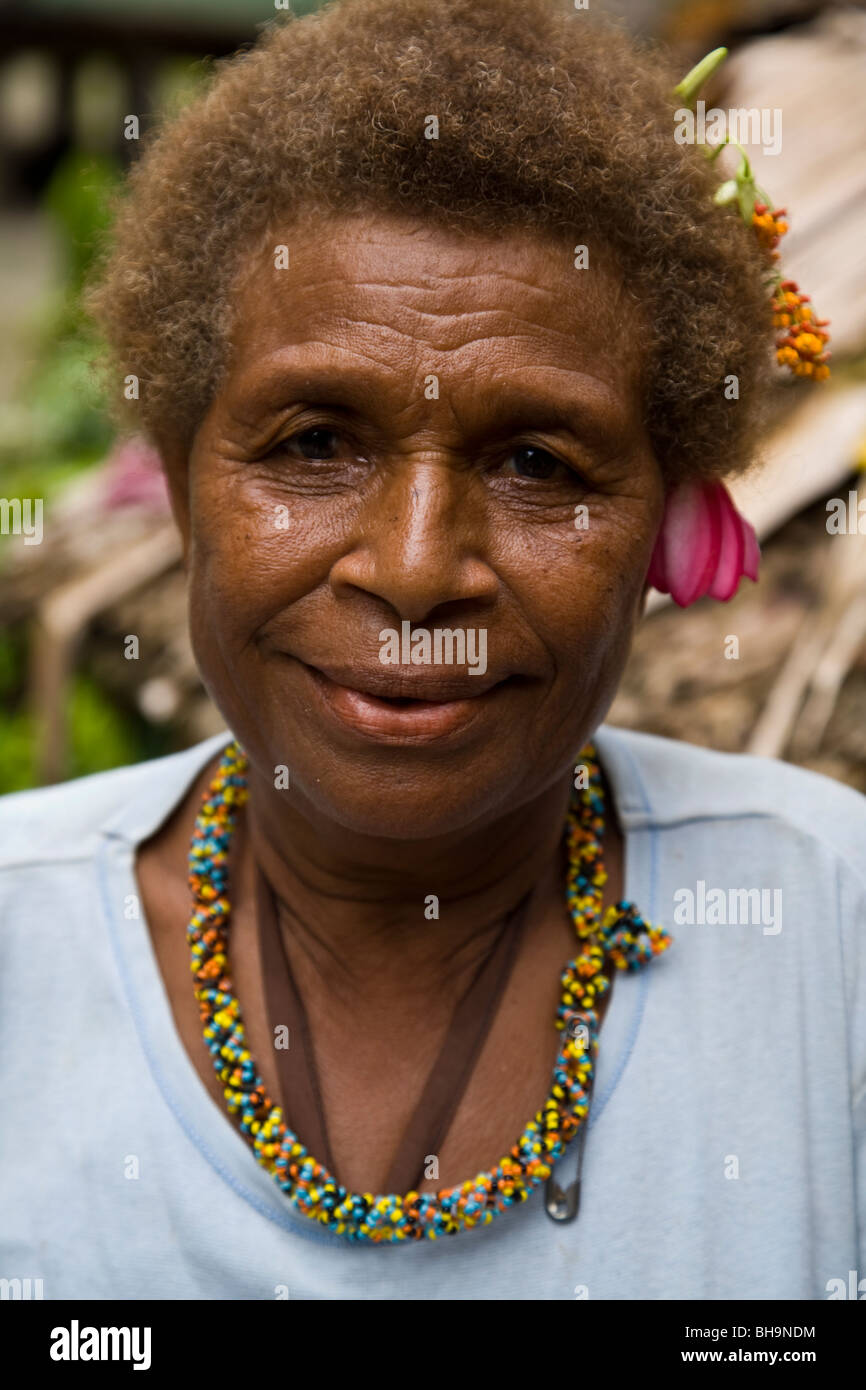 Close up della Melanesian donna con la tradizionale collana di perle e fiori nei suoi capelli Foto Stock