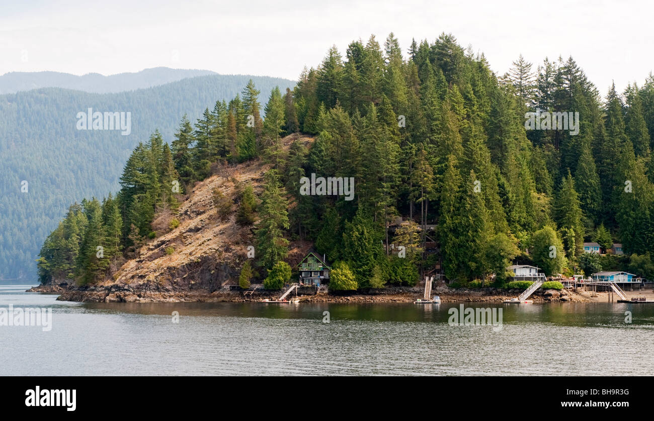 Case sul lungomare al Cosy Cove, Belcarra Park, Braccio indiano, vicino a Vancouver, BC, Canada. Caraffa Island può essere visto a sinistra. Foto Stock