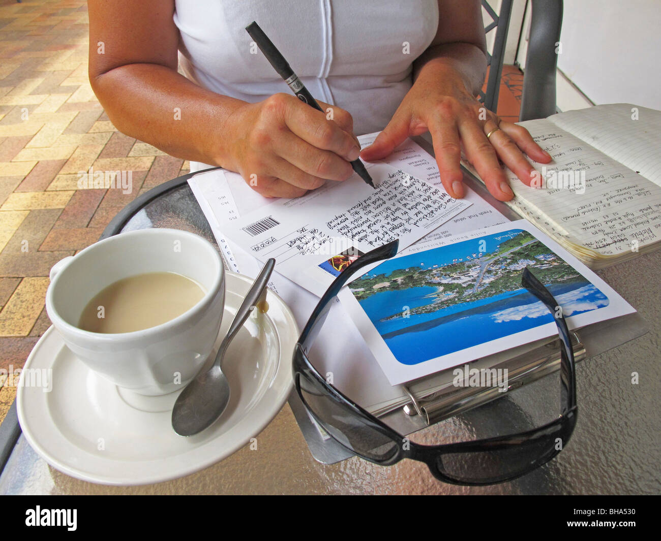 Donna scrivere cartoline in vacanza a Airlie Beach nel Queensland Foto Stock