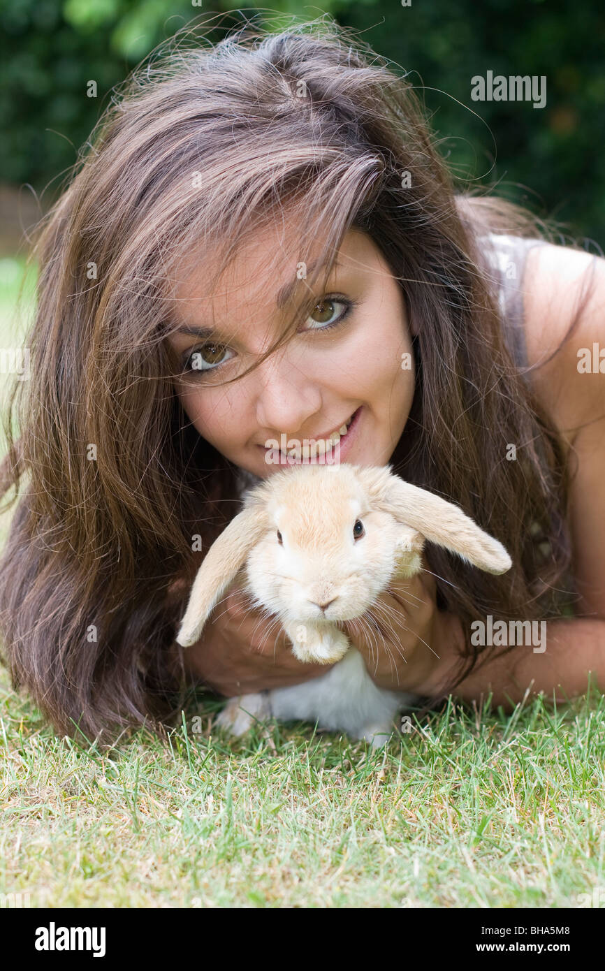 Ragazza adolescente con Lop Eared Baby coniglio in giardino Foto Stock