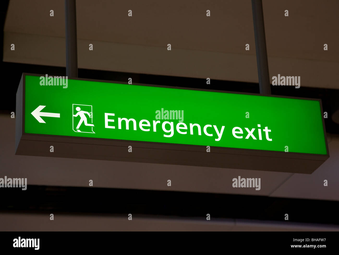 Uscita di emergenza segno in aeroporto, terminale 5, l'aeroporto di Heathrow a Londra, Inghilterra Foto Stock