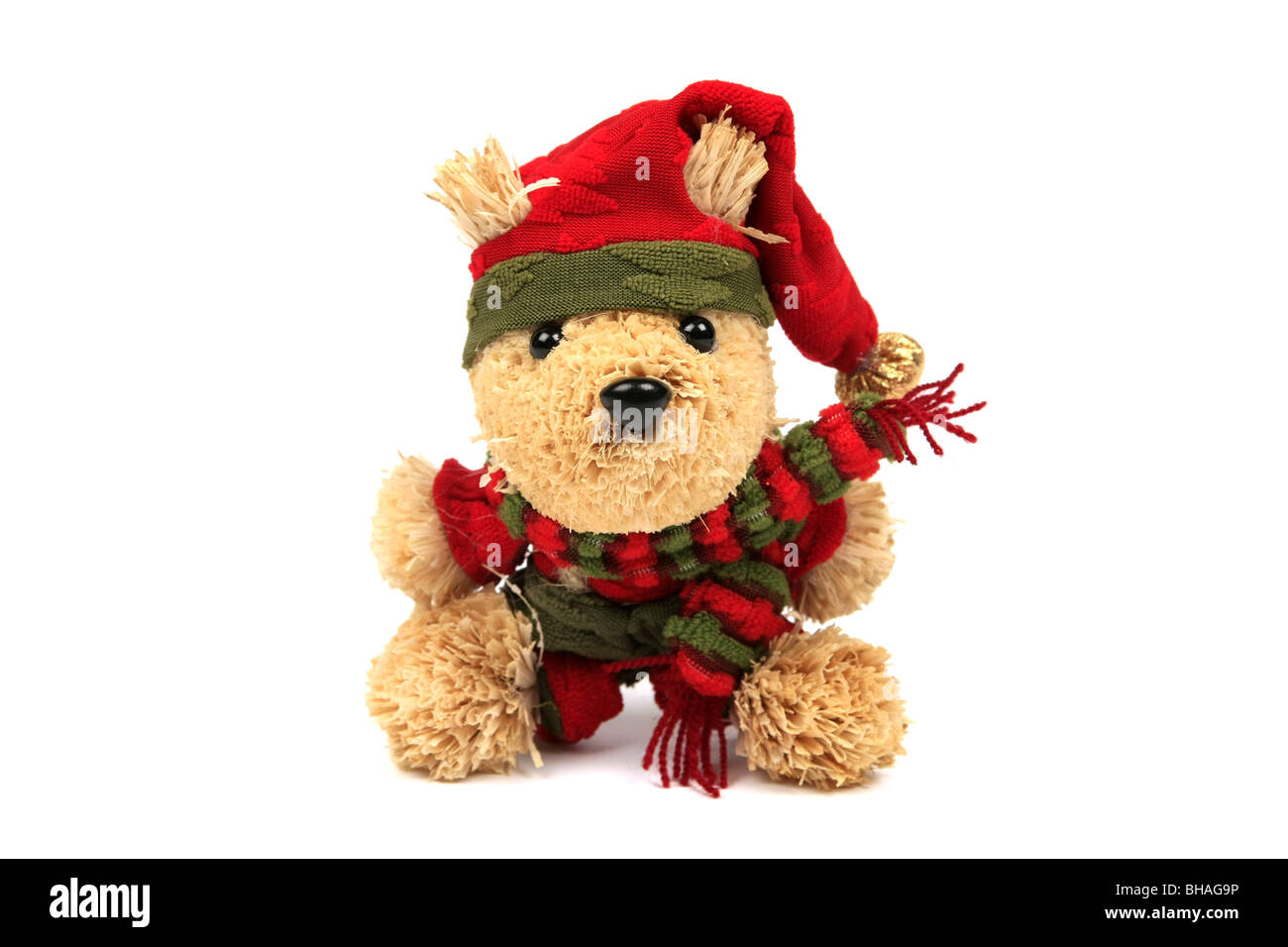 Orsacchiotto di peluche che indossa un cappello rosso e sciarpa contro uno sfondo bianco Foto Stock