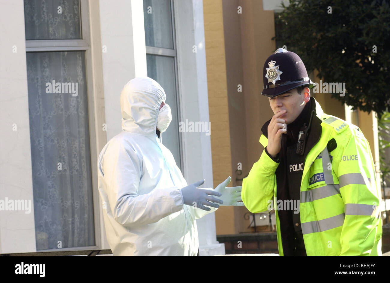 Scena del crimine officer colloqui con una polizia constable dopo un attacco mortale UK. Foto Stock
