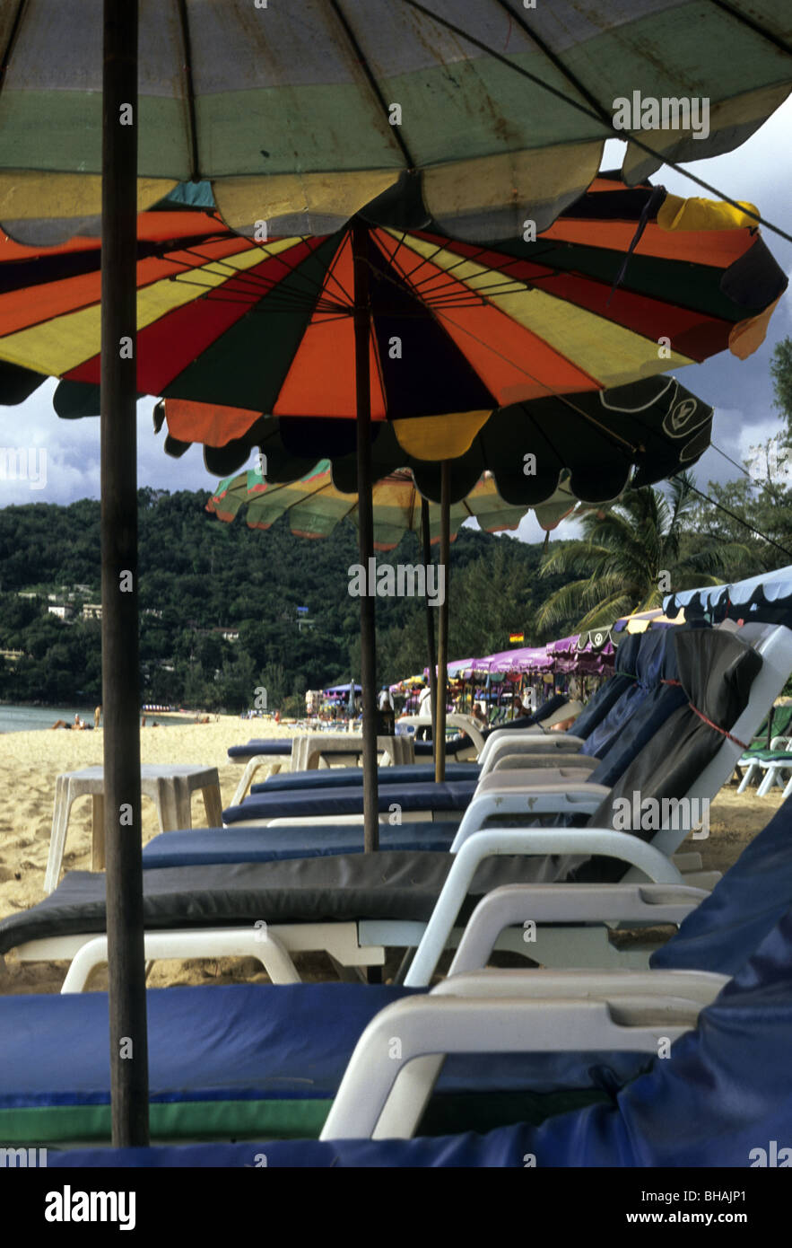 Una fila di sedie a sdraio e ombrelloni linea Karon Beach in Phuket, Tailandia Foto Stock