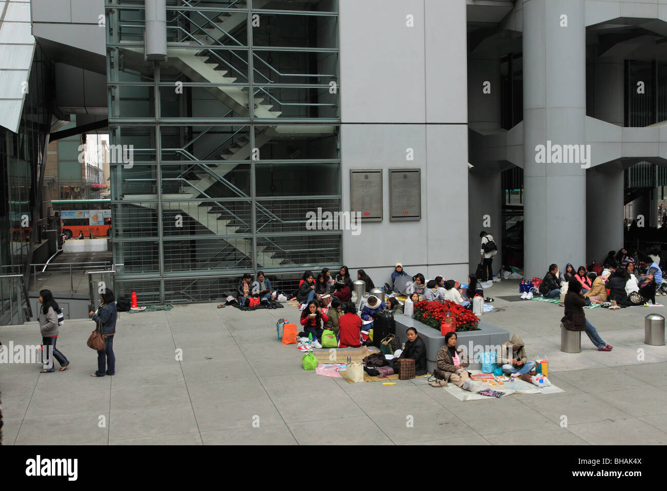 Cameriere filippino raccogliere una domenica sotto la HSBC Building a Hong Kong Foto Stock