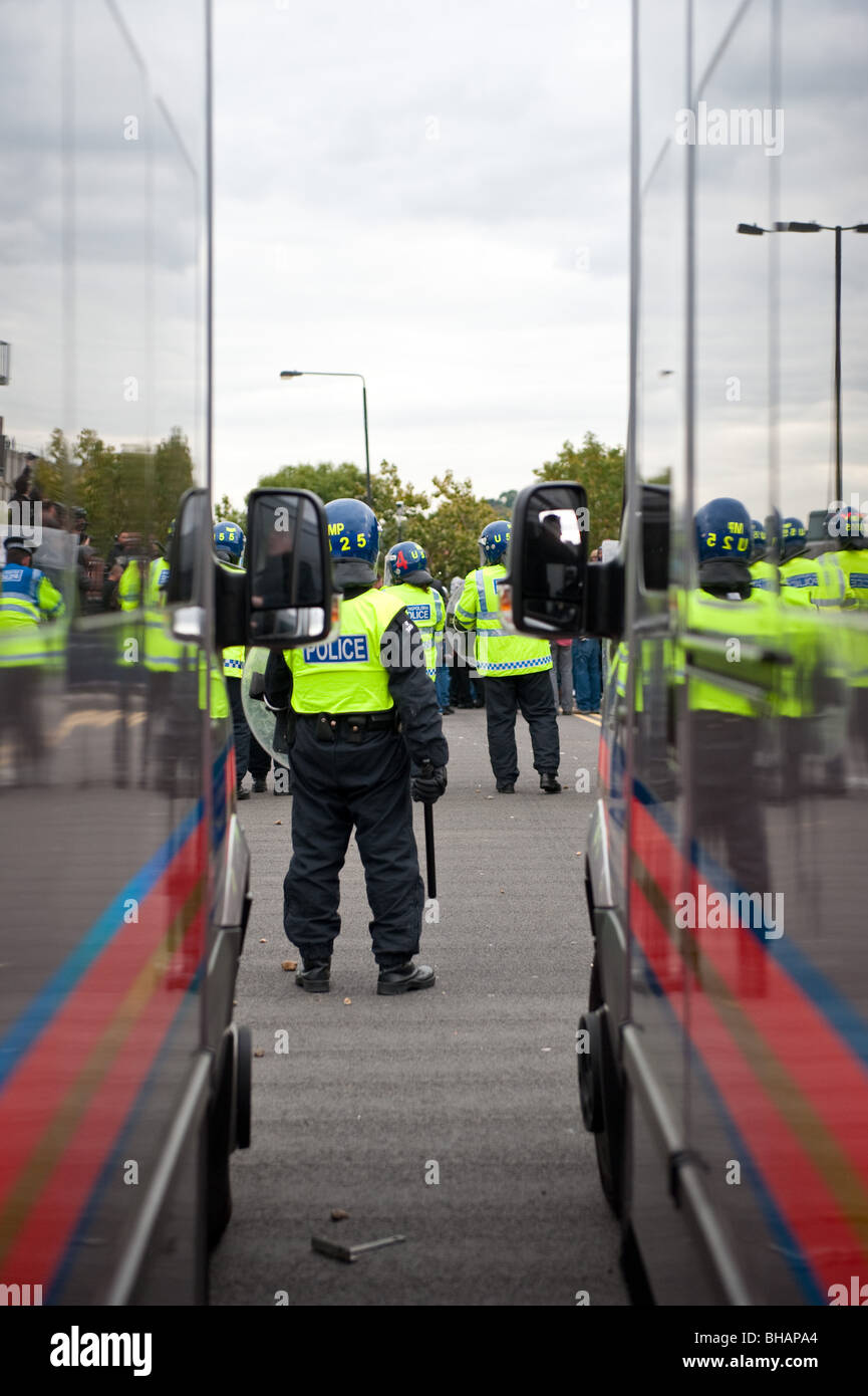 Anti-sommossa poliziotti in piedi vicino a furgoni di polizia Foto Stock