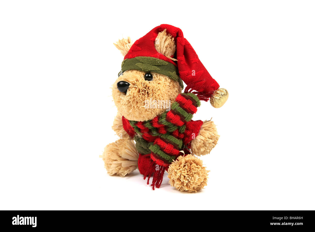 Orsacchiotto di peluche che indossa un cappello rosso e sciarpa contro uno sfondo bianco Foto Stock